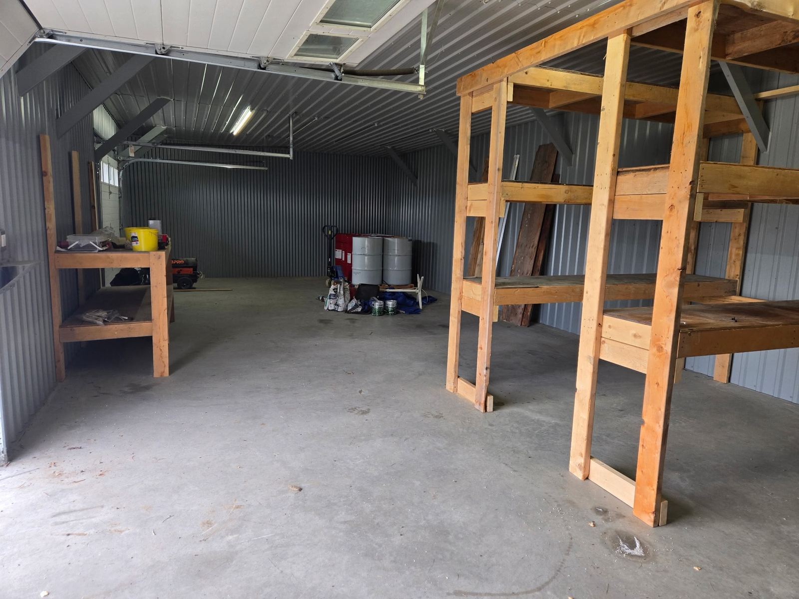 Interior of the Osgoode Storage barn with wooden shelving and open floor space for snowmobiles and seasonal gear.